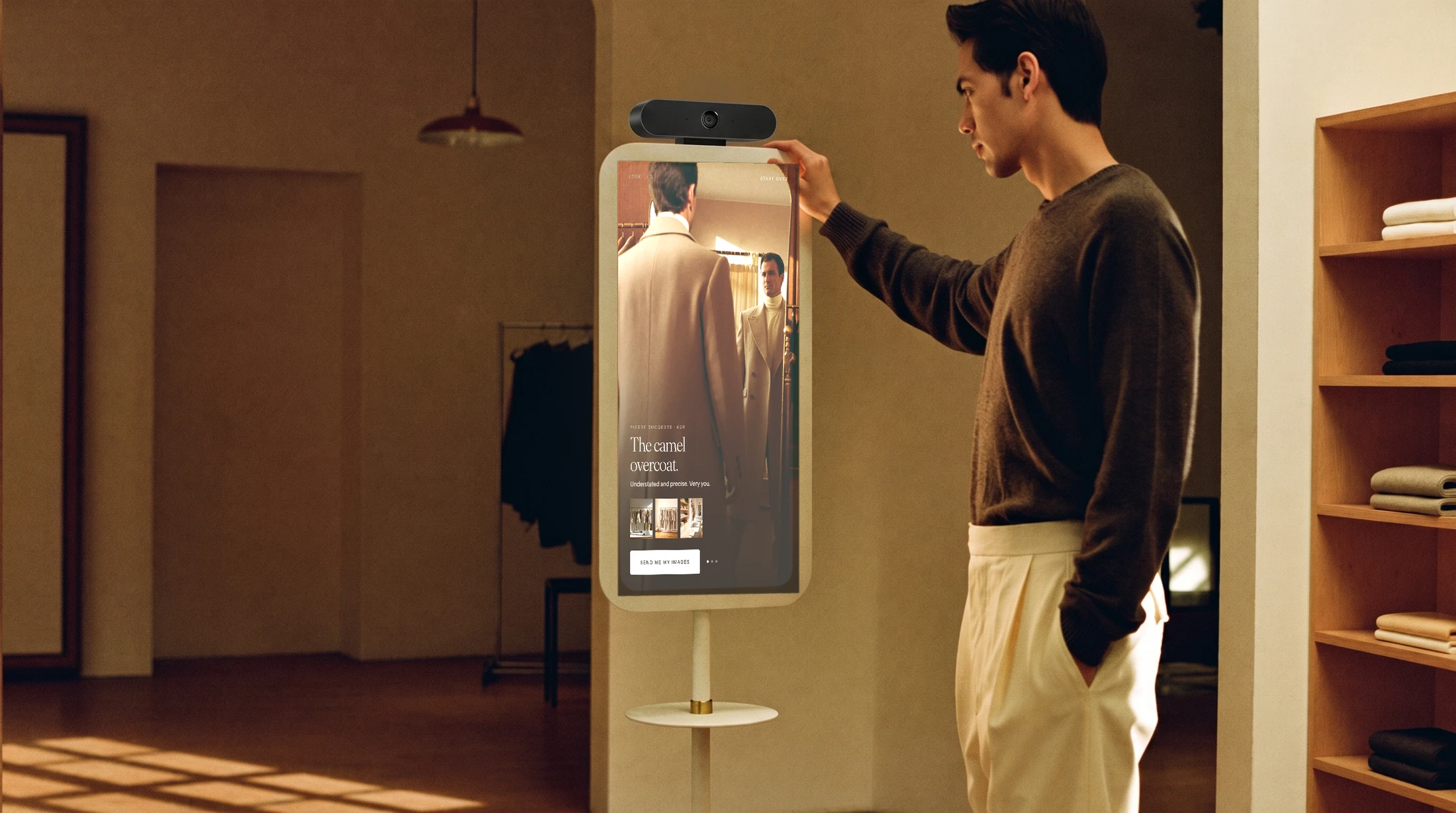 A man touching an ApoloSign panel in a boutique; the screen shows him the camel overcoat Pierre styled for him.